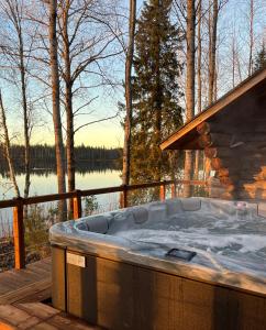 een hot tub op een terras met uitzicht op een meer bij Lapland Dream Destinations in Rovaniemi