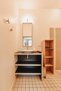 een badkamer met een wastafel en een spiegel bij Le Cocon Carmel by CozyLife in Niort