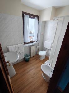 a bathroom with two toilets and a sink and a window at Hotel Genevris Cinq in Sauze dʼOulx +24 photos