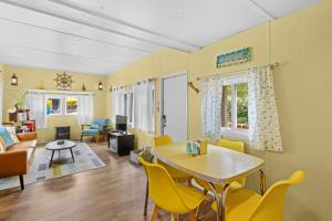 a living room with a table and yellow chairs at Beautiful Decorated Cozy Retreat in Rockaway Beach