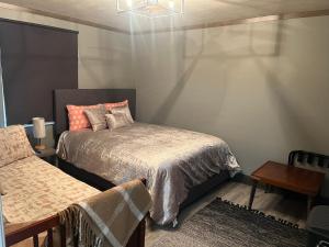 ein Schlafzimmer mit einem Bett, einem Tisch und einem Bettrock in der Unterkunft Modern Glass City Home in Toledo