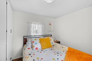 a bedroom with a bed with a yellow pillow at Beautiful Decorated Cozy Retreat in Rockaway Beach