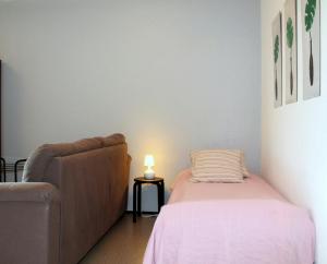 une chambre avec un lit, un canapé et une lampe dans l'établissement Convenient Apartment for 3 in Varissuo, à Littoinen
