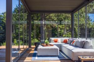 a living room with a white couch and glass walls at Crown Point Hideaway in Crown Point