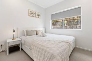 a white bedroom with a bed and a window at Modern House with Patio and Family Comfort) in Park Ridge
