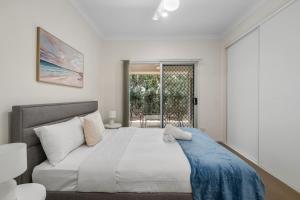 a bedroom with a large bed and a window at Charming 2BR Home in Serene Mount Warren Park in Windaroo
