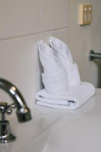 a stack of towels sitting on a bathroom sink at Charming 2BR Home in Serene Mount Warren Park in Windaroo +20 photos