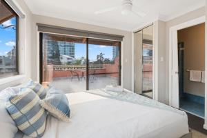 Modern 2BR Apartment Beach and Dining in Broadbeach في غولد كوست: غرفة نوم بها سرير ونافذة كبيرة