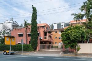 Modern 2BR Apartment Beach and Dining in Broadbeach في غولد كوست: مبنى به شجرة طويلة بجوار الشارع