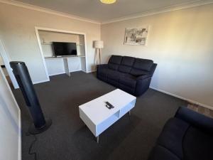 グラフトンにあるApartments on Turf Unit 4のソファとテレビのあるリビングルーム