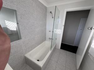 グラフトンにあるApartments on Turf Unit 4の白いバスルーム(シャワー、バスタブ付) +11枚の写真