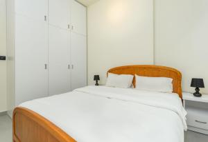 a white bedroom with a large bed with white walls at Curl 2-Bedroom Apartment in Gemmayzeh in Ar Rumayl