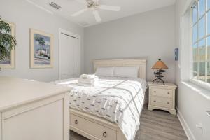 a white bedroom with a bed and a window at Funky Fish House Villa in Shell Point Village +42 photos