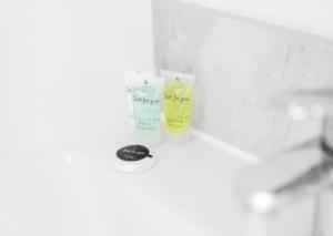 een wastafel in de badkamer met daarop twee flessen ontsmettingsmiddel bij Cozy 2 Bed Apartment - Parking - Netflix 27AC in Sleightholme