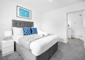 een slaapkamer met een groot bed en een spiegel bij Cozy 2 Bed Apartment - Parking - Netflix 27AC in Sleightholme