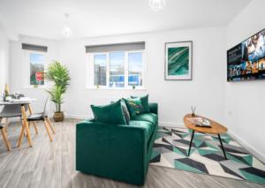 een woonkamer met een groene bank en een tafel bij Cozy 2 Bed Apartment - Parking - Netflix 27AC in Sleightholme
