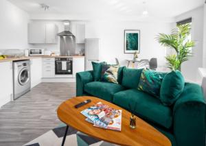 een woonkamer met een groene bank en een tafel bij Cozy 2 Bed Apartment - Parking - Netflix 27AC in Sleightholme