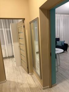 a room with two mirrors and a living room at Vecpilsētas apartaments in Cēsis