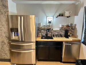 eine Küche mit einem Kühlschrank aus Edelstahl und einer Spüle in der Unterkunft Modern Glass City Home in Toledo + 15 Fotos