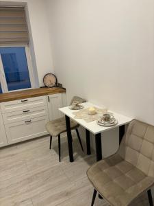 a kitchen with a table and chairs and a window at Vecpilsētas apartaments in Cēsis +6 photos