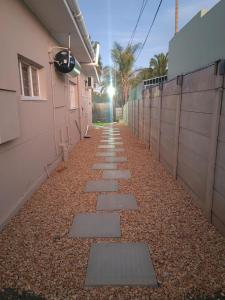 Un sendero con rocas, un edificio y una valla. en WegkruiperQ, en Beaufort West