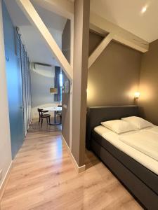 a bedroom with a bed and a table in a room at Stadslogement By Peek in Sneek