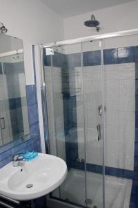 bagno con doccia in vetro e lavandino di Belvedere a Procida