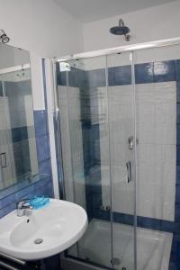 a bathroom with a glass shower and a sink at Belvedere in Procida