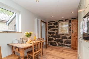 a kitchen and dining room with a table and chairs at Muriau-Bach in Dolbenmaen