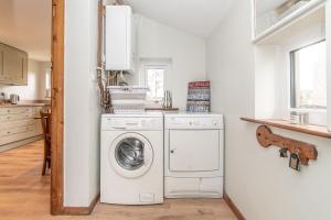 a washer and dryer in a white kitchen at Muriau-Bach in Dolbenmaen