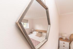 a mirror hanging on a wall in a bedroom at Muriau-Bach in Dolbenmaen
