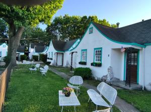 een wit huis met stoelen en tafels in de tuin bij Crescent Court in Branson
