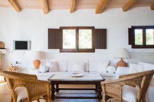Una sala de estar con un sofá blanco y una mesa. en Finca Fiori 2, en Is Molas 