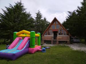 a playground with a slide and a house at Cabaña Familiar in Jilotepec