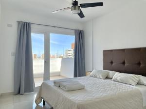 a bedroom with a bed and a large window at Zeta Inn - Departamentos en pleno centro - Neuquén Capital in Neuquén