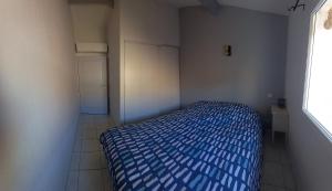 a bedroom with a blue bed in a room at Maison au pin in Narbonne-Plage