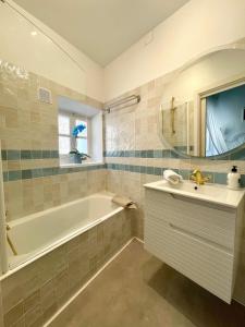 ein Badezimmer mit Badewanne, Waschbecken und Badewanne Tubermottermott in der Unterkunft Marina 48 Seafront Apartment in Port de Sóller