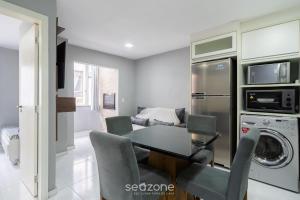 a kitchen and dining room with a table and a refrigerator at Aptos em prédio a 500m da Praia de Canasvieiras - GALs in Florianópolis