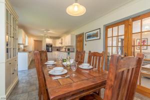 a dining room with a wooden table and chairs at Ty-Ffynnon in Penmaen-mawr