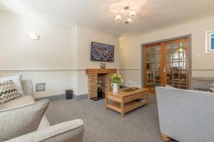 a living room with a couch and a fireplace at Ty-Ffynnon in Penmaen-mawr