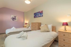 a bedroom with two beds and a dresser at Ty-Ffynnon in Penmaen-mawr