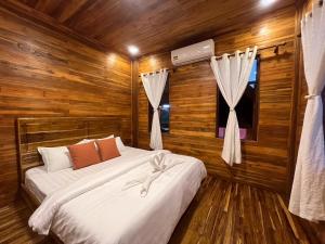 a bedroom with two beds in a room with wooden walls at Wang Namthip Hotel in Muang Fuang +17 photos