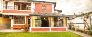 a house with a bench in front of it at Casa del Huesped in Otavalo