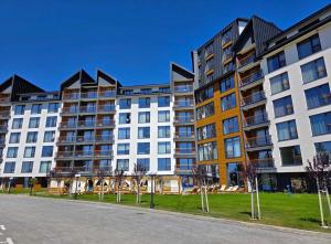 an apartment building with trees in front of a street at Alpina Lux in Kopaonik
