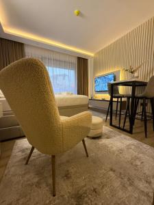 a living room with a chair and a table at Alpina Lux in Kopaonik