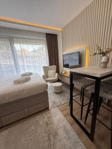 a bedroom with a bed and a desk and a table at Alpina Lux in Kopaonik