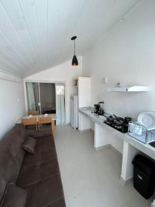 a living room with a couch and a kitchen at Flat Gute Morro - Praça Central in Cairu