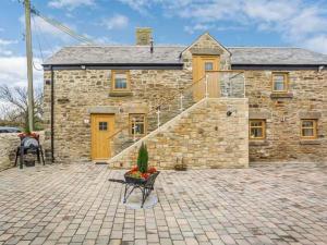 ein Steinhaus mit einer Treppe davor in der Unterkunft Wagtail Cottage-Ukc6984 in Castleside