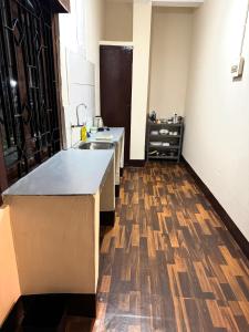 a kitchen with a sink and a wooden floor at Varnas Cosy Stay in Guwahati