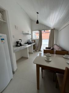un salon avec une table et une cuisine dans l'établissement Gute Morro Villa Apartments, à Cairu